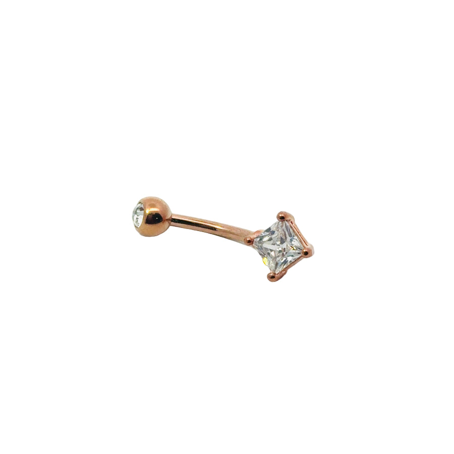 Rose gold belly button bar with a clear gemstone on a white background