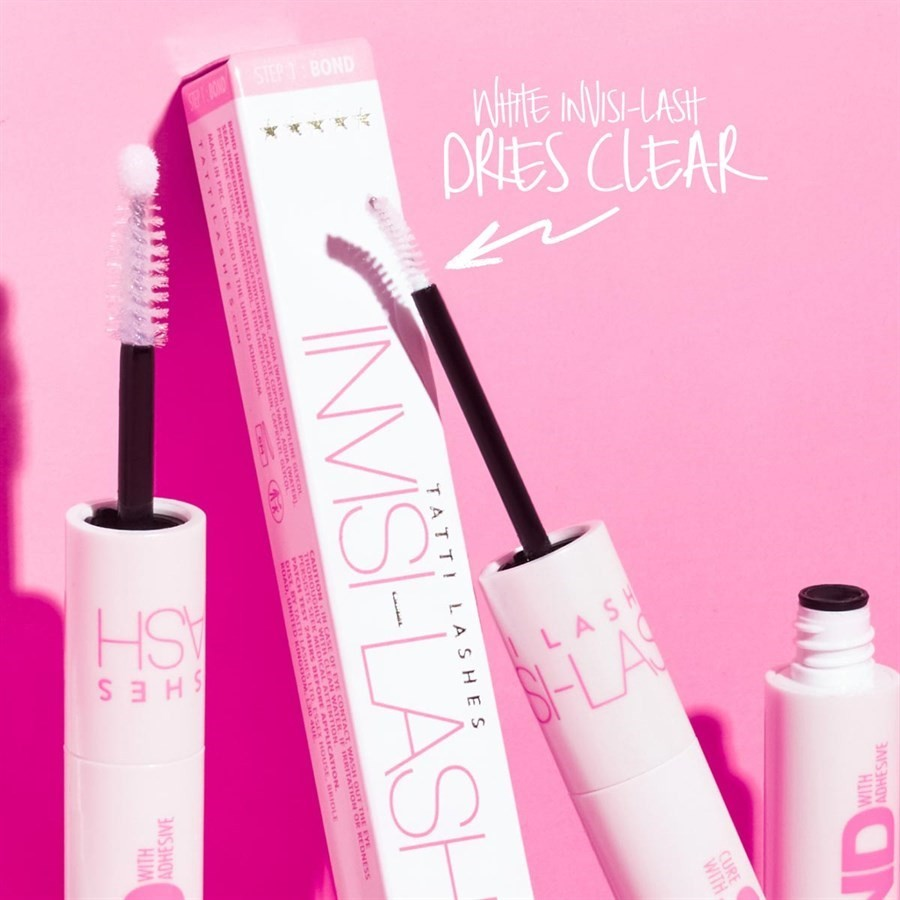 invisilash product image with the packaging open. It shows and open white mascara style wand on a black stick. There is text pointing to the wand that says 'white invisilash dries clear'