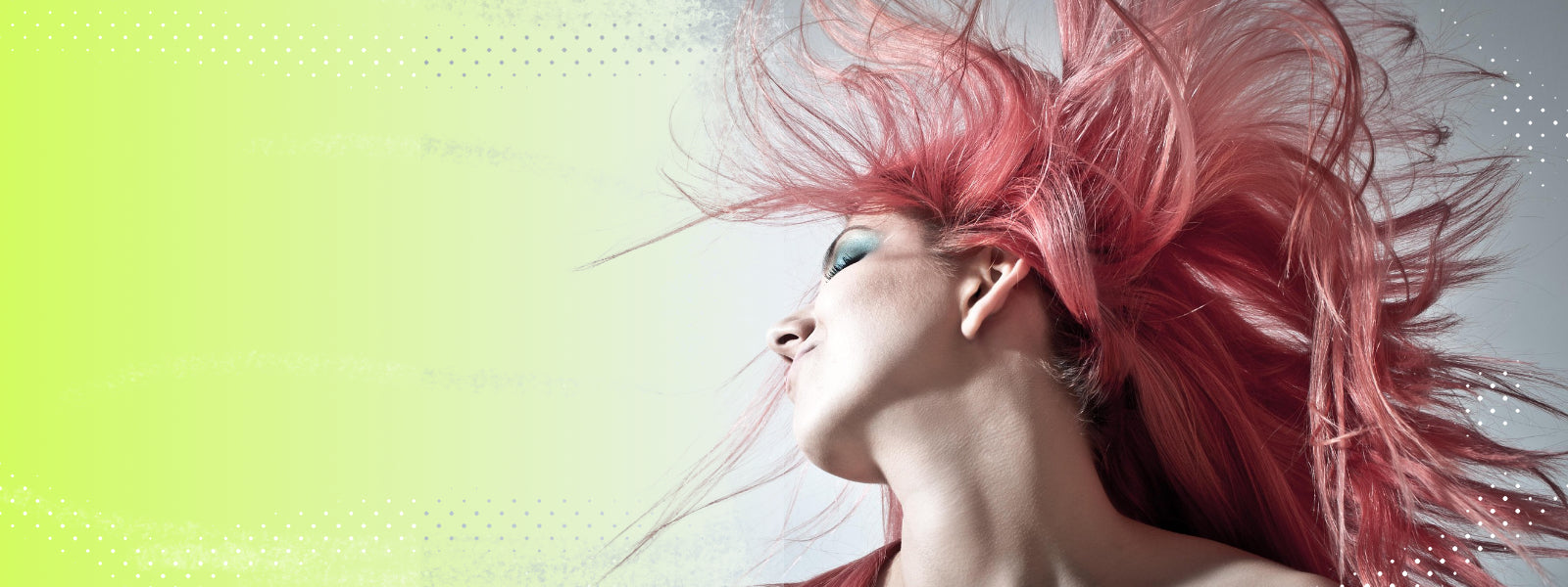 Woman with pink hair blowing in the wind against a light green background