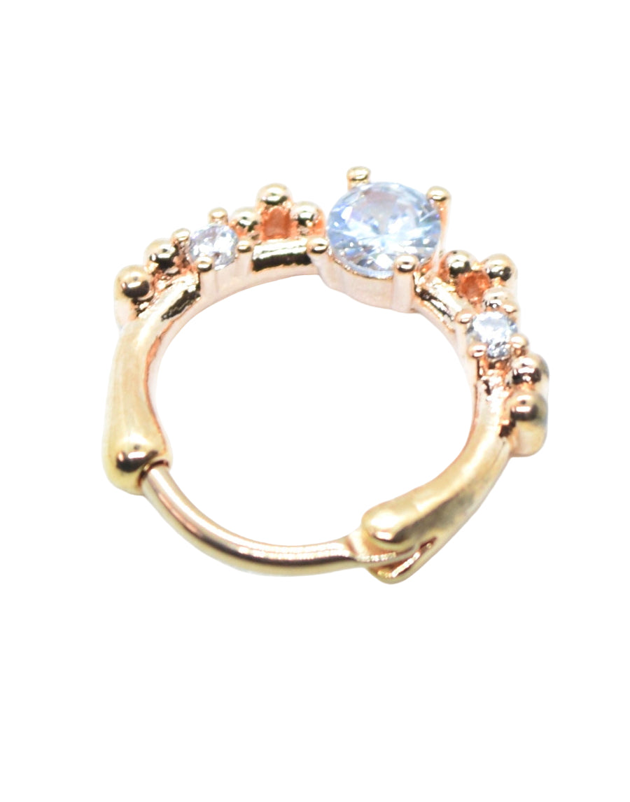 A rose gold clicker ring with a central diamante and small surrounding stones.