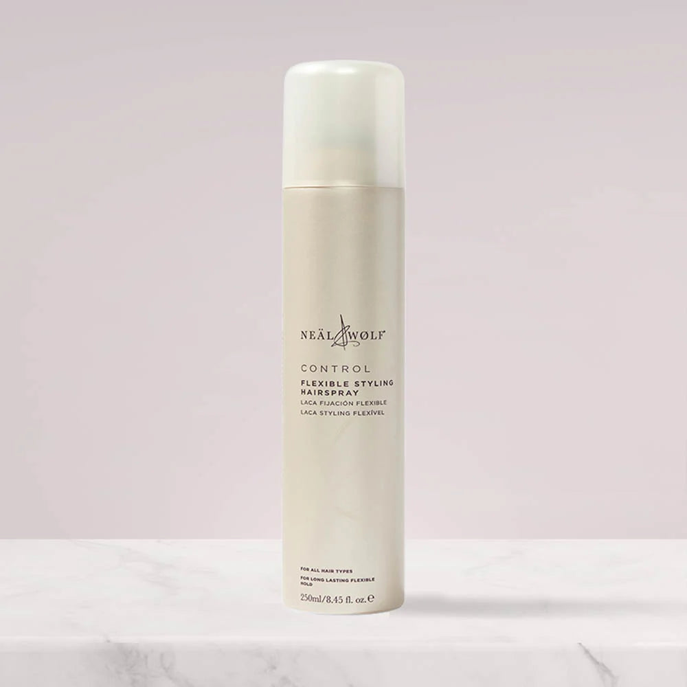 Neal & Wolf hair spray bottle on a light pink background