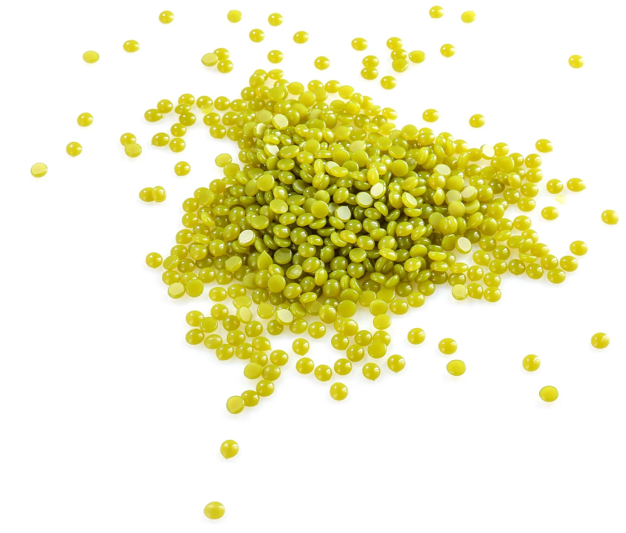 Lime green coloured wax pellets on a white background