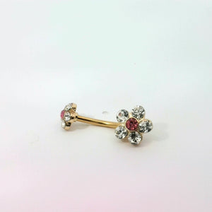 Gold belly button ring with floral design and red gemstones on a white background