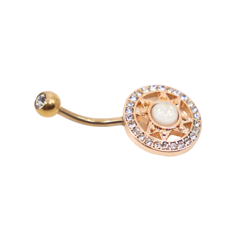 Rose gold coloured ornate navel bar in a circular design and central gem on a white background