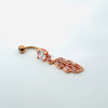 Rose gold belly button ring with feather design on a white background