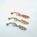 Three belly button rings with leaf-shaped pendants on a white background
