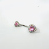Belly button ring with pink gemstones on a white background