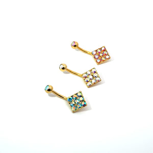 Three gold belly buttons with colorful gemstones on a white background