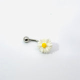 Belly button ring with a daisy flower design on a white background