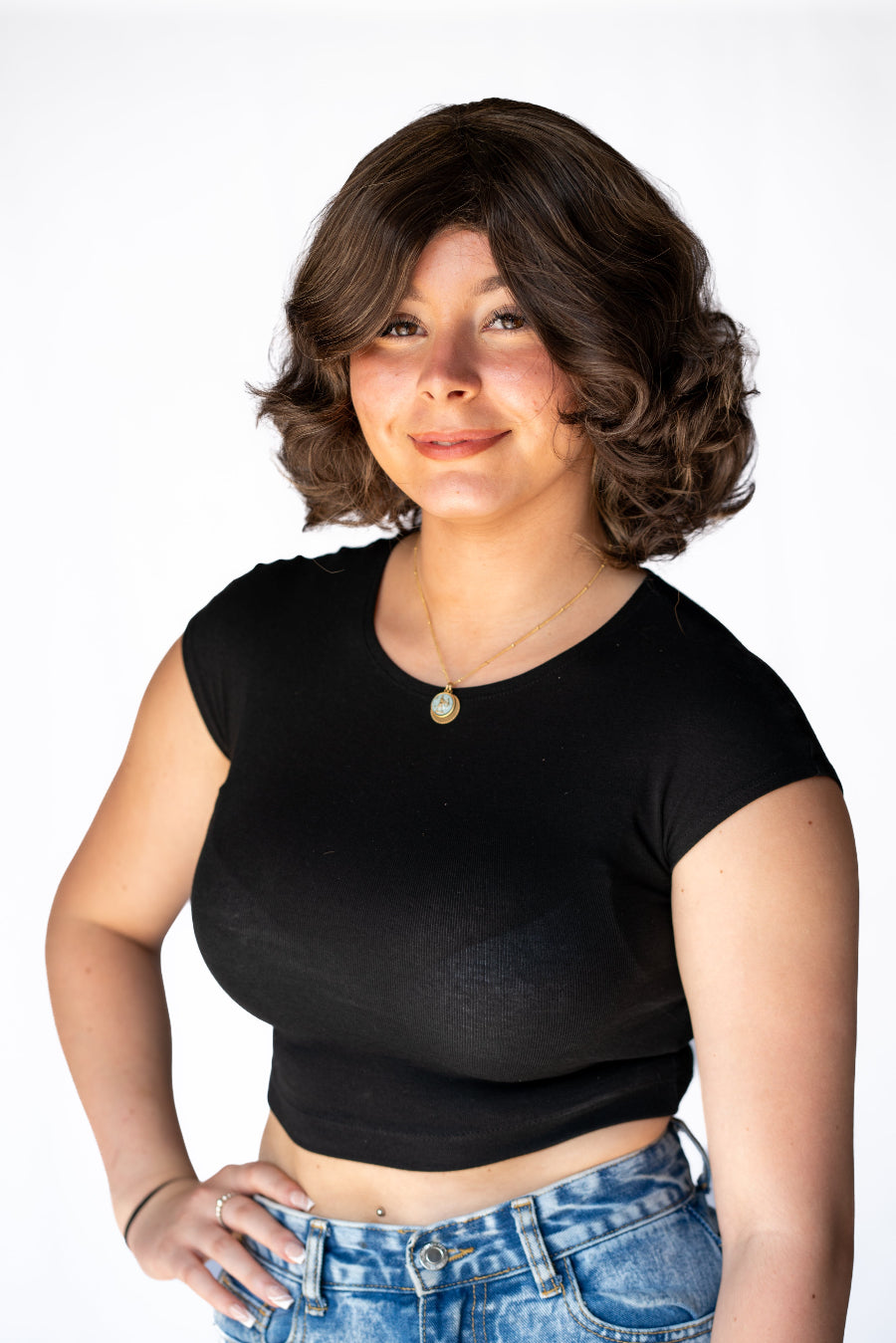 A woman is wearing a dark brown synthetic wavy wig with a breathable cap.