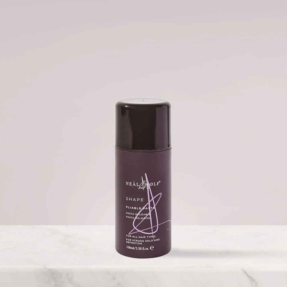 Purple hair product bottle with brand name on a light gray background