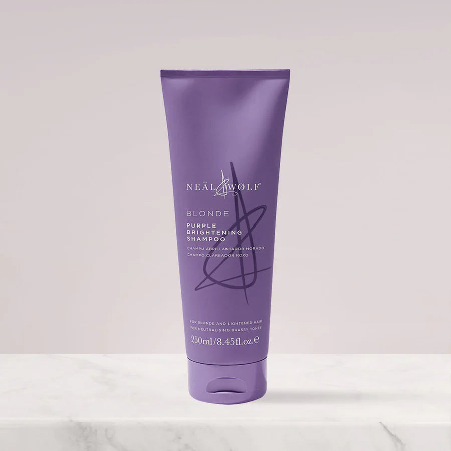 Purple shampoo bottle with 'Neal & Wolf' branding on a light gray background