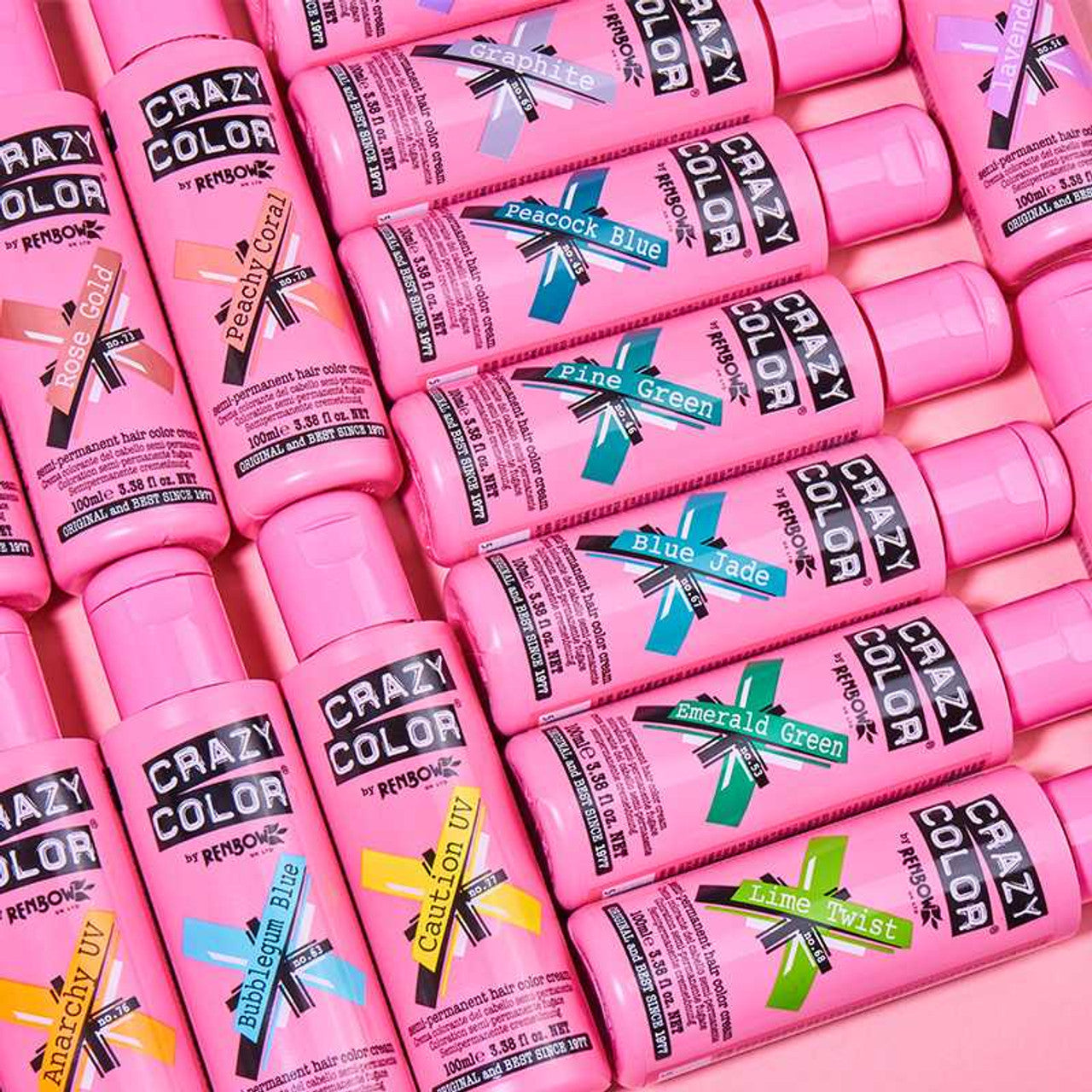 Multiple bottles of Crazy Color hair dye in various colors on a pink background