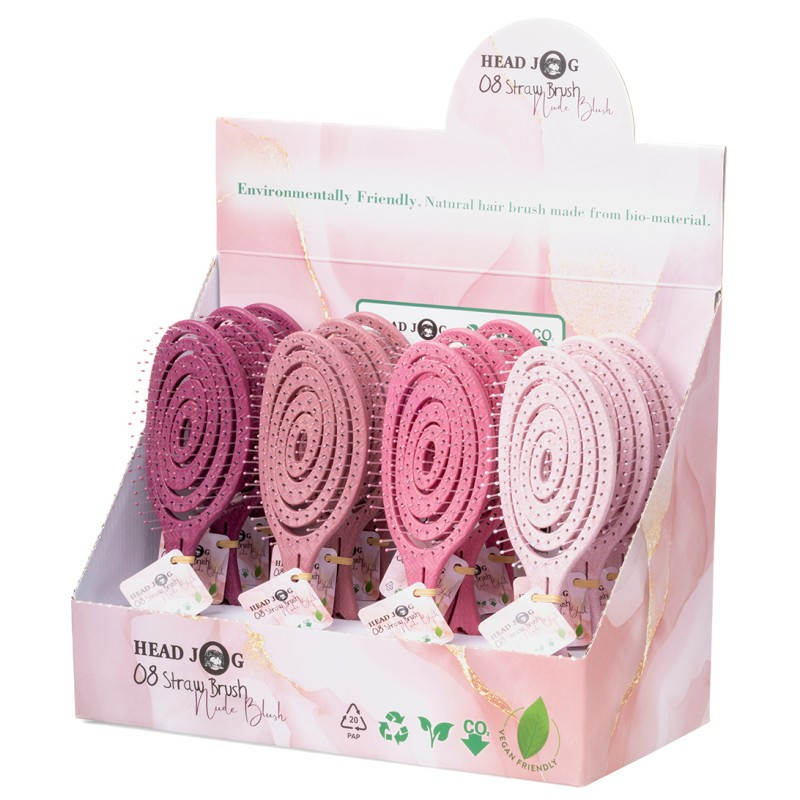 A display box containing multiple nude-colored straw hair brushes with flexible loop bristles.