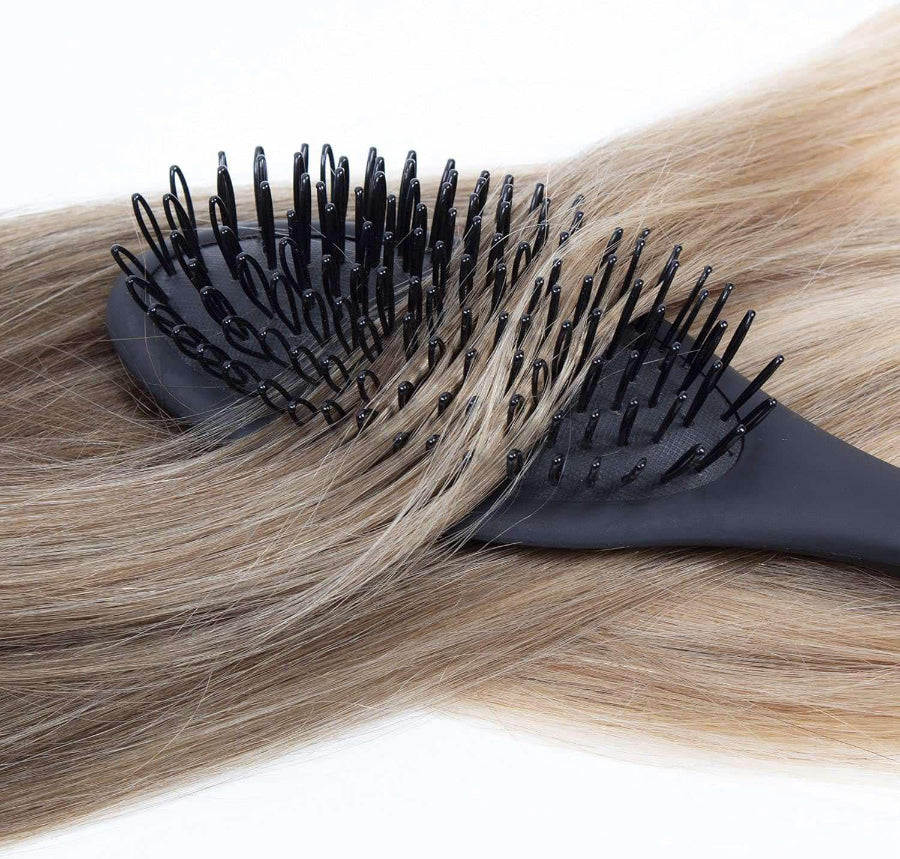 looped bristle hair brush with hair laid across the bristles